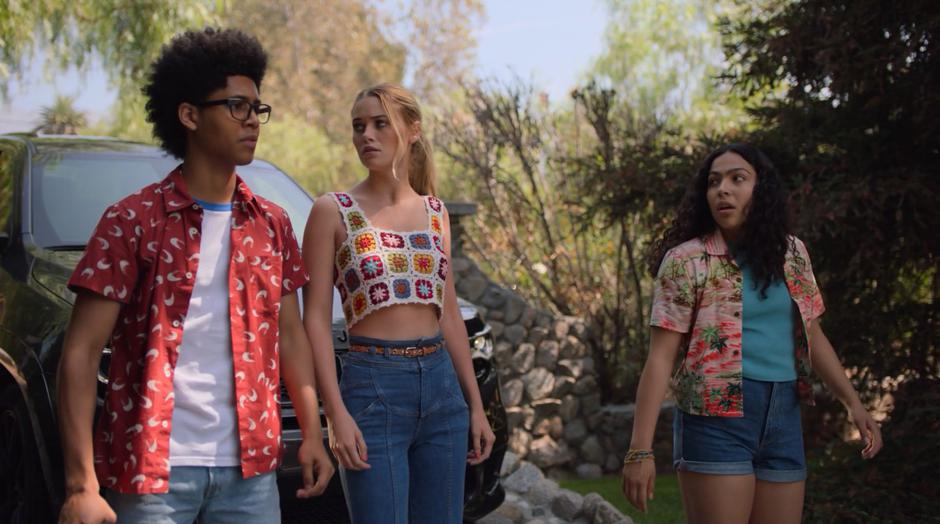 Alex, Karolina, and Molly step in front of their car and look at the house.