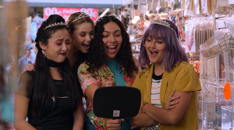 Nico, Karolina, Molly, and Gert post in front of mirror with tiaras.