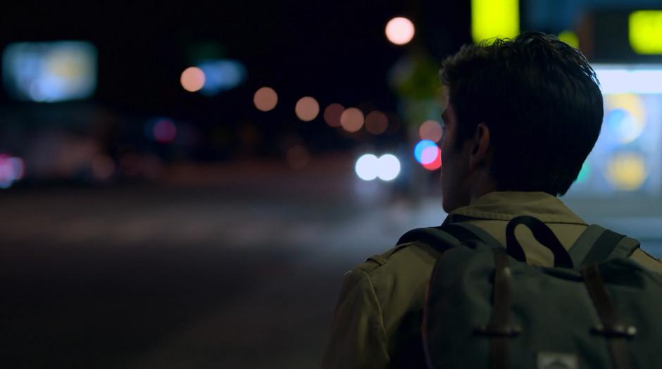 Chase walks down the sidewalk at night.