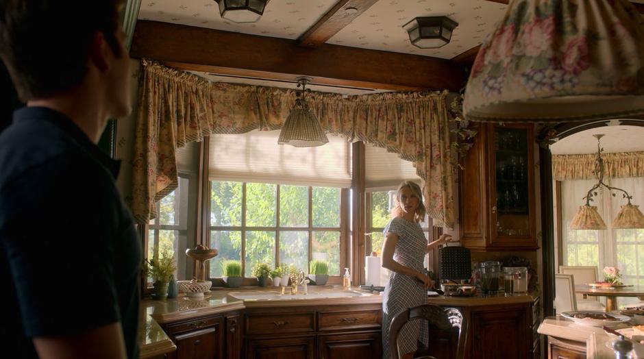 Janet turns around from where she is preparing waffles as Chase enters the kitchen.