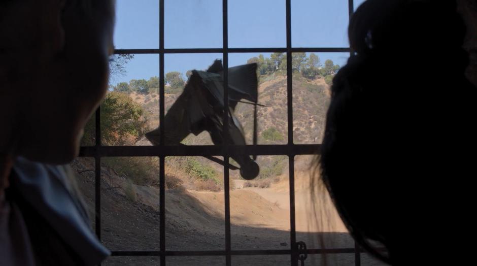 One of the drones crashes into the fence which Karolina and Nico are hiding behind.