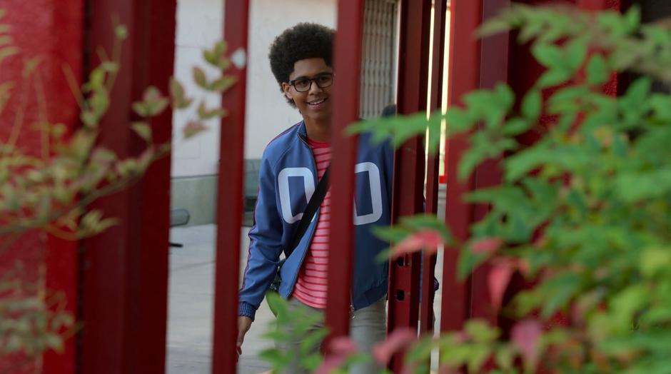 Alex watches from behind a gate as his parents are arrested.