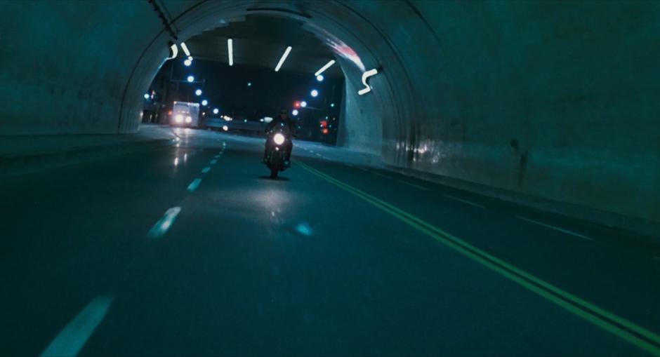 The Terminator drives into the tunnel on his motorcycle.