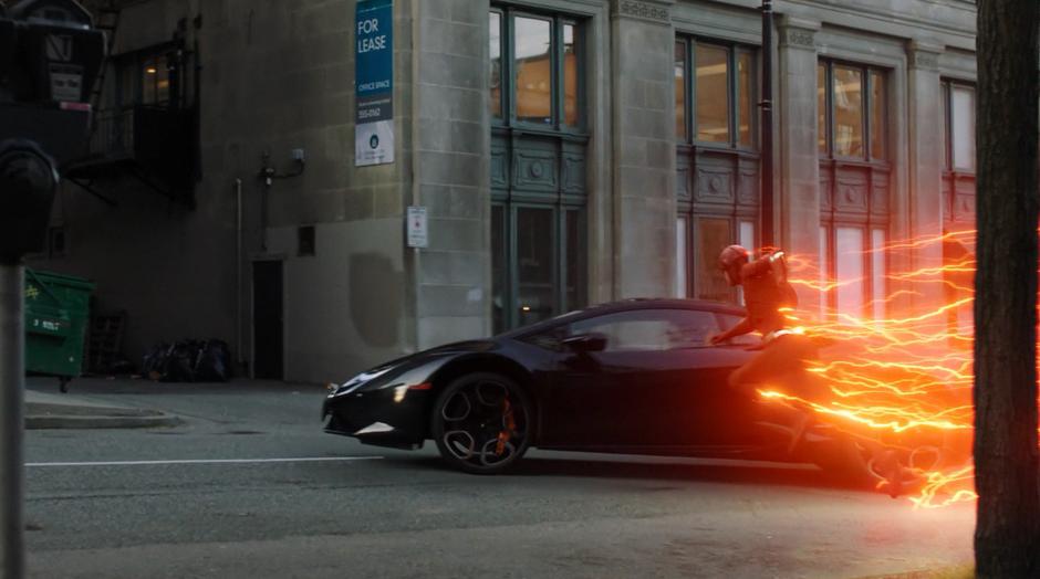 Barry reaches for the stolen car as it turns the corner.