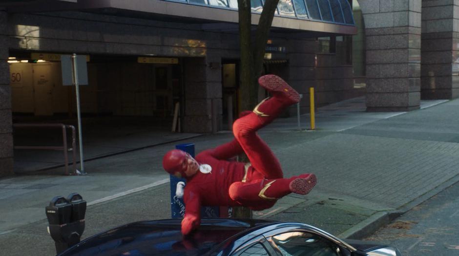 Barry crashes down onto a parked car.