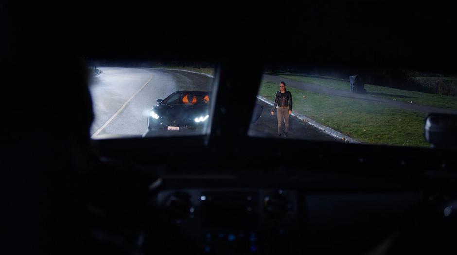 Raya Van Zandt steps out of the stolen car in front of the armored truck.