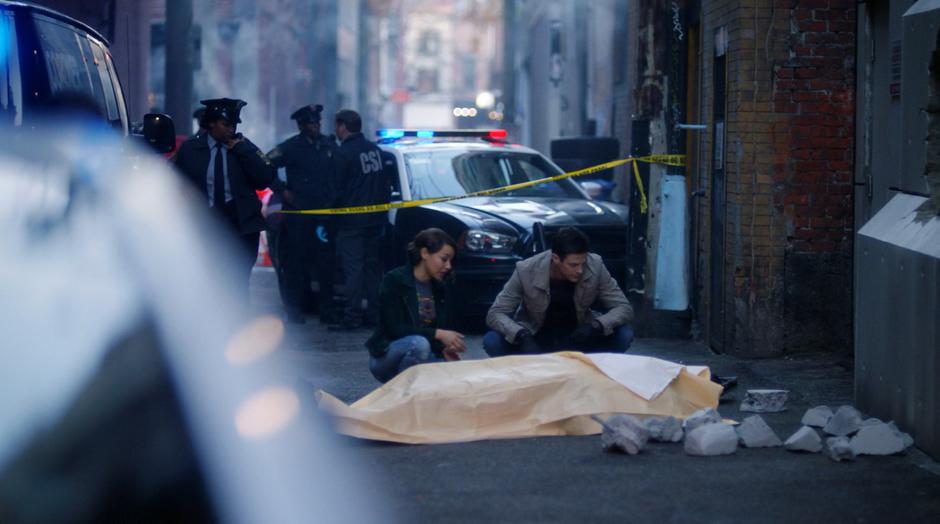 Nora and Barry kneel down over the covered body of Carl Bork.