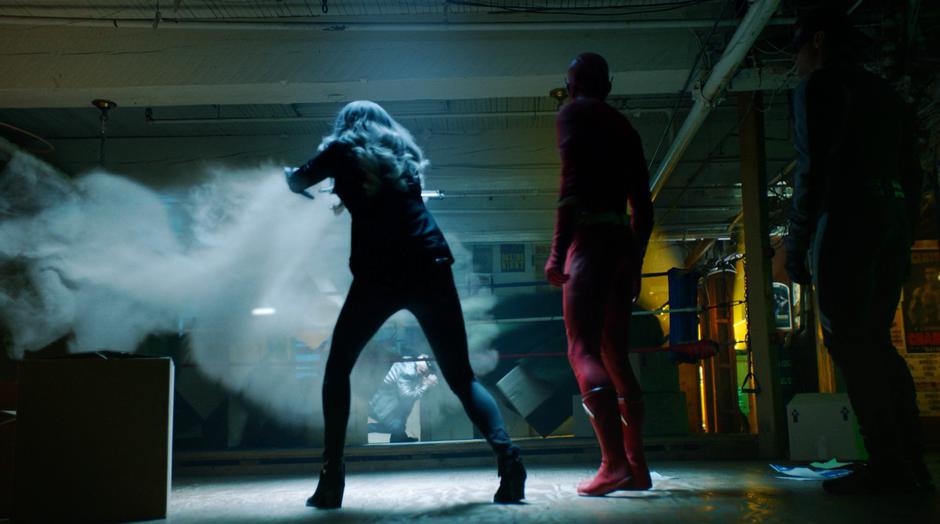 Killer Frost lets out a burst of air which blows over some boxes to reveal Norvock.