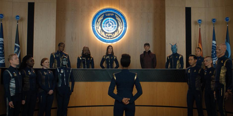 Michael gives a speech to the admirals while surrounded by the crew of the Discovery.