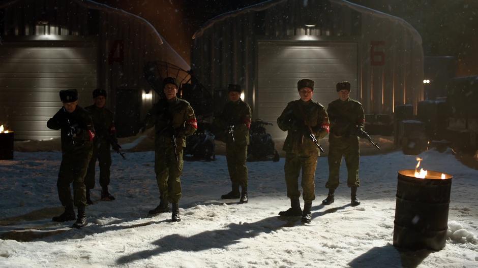 Several Russian soldiers with guns out come to a stop.