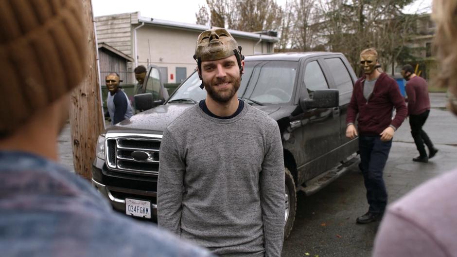 One of the Children of Liberty smiles as Jerry and Kyle as his associates climb out of their car and walk over towards them.