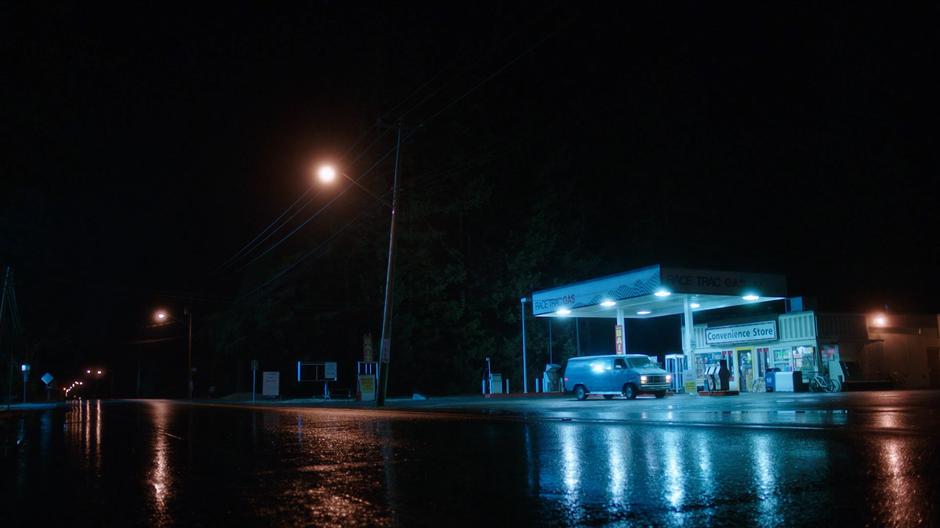 The van pulls to a stop in front of the gas station.