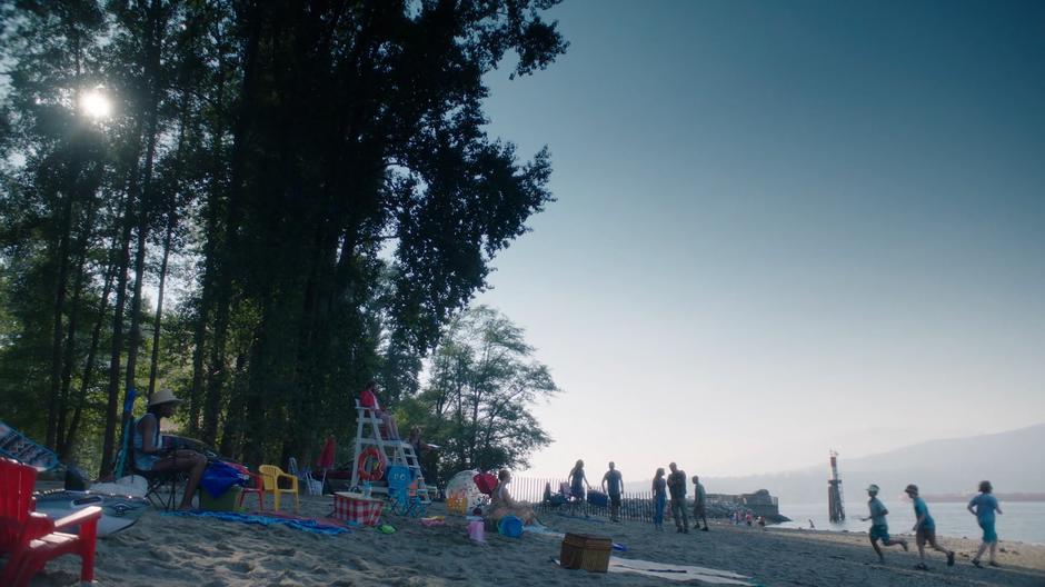 Ryn and Ben talk on the busy beach during the day.