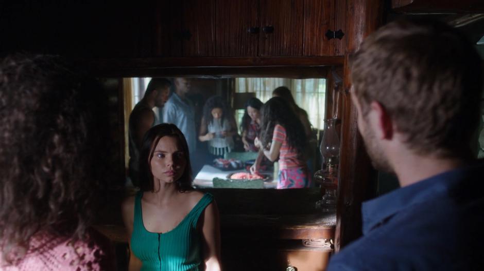 Ryn talks to Maddie and Ben in the kitchen while the rest of the mermaids eat their meal in the main room.