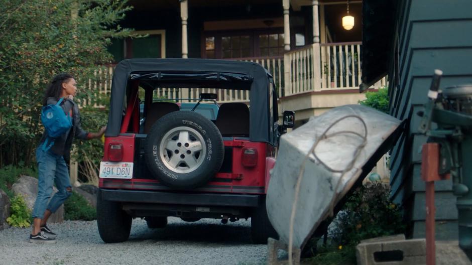 Maddie closes the door of her Jeep which she parked behind her house.