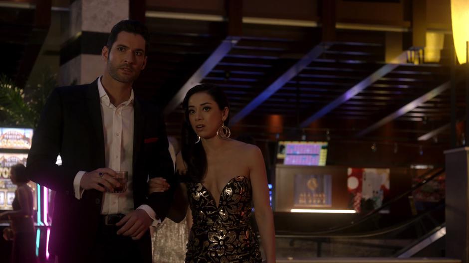 Lucifer and Ella look across the casino floor at Roxie Pagliani.