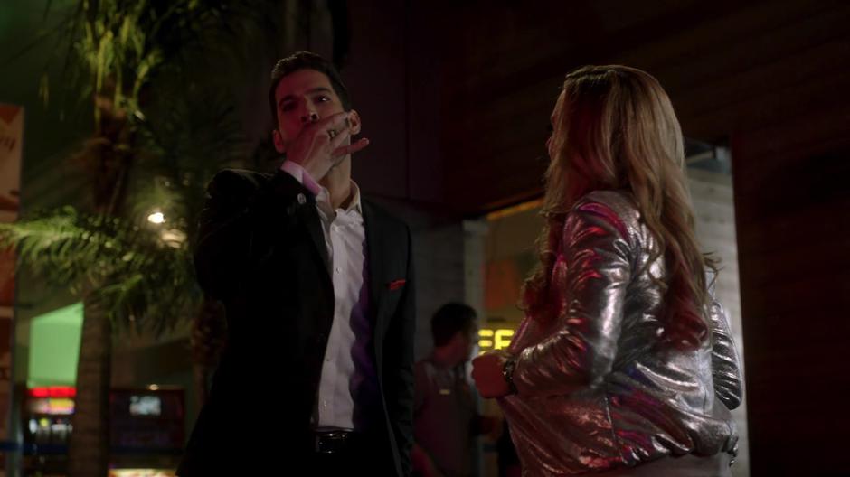 Lucifer whistles at Ella to stop her flirting after he finishes talking with Candy.