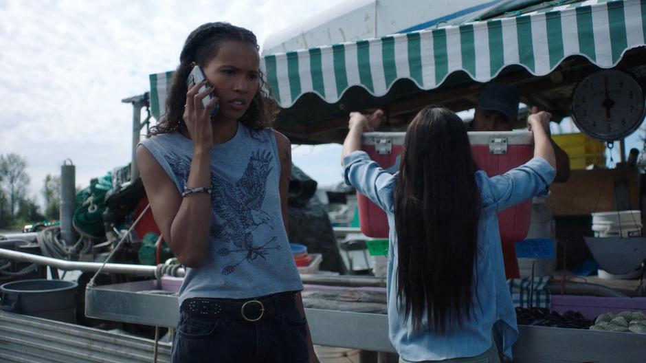 Maddie talks to Ben on the phone while Ryn collects the cooler of fish.