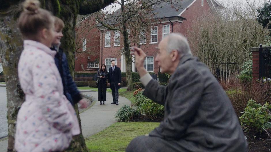 Mel and Harry watch from the distance while Carter Westwell performs a magic trick for his two grandchildren.