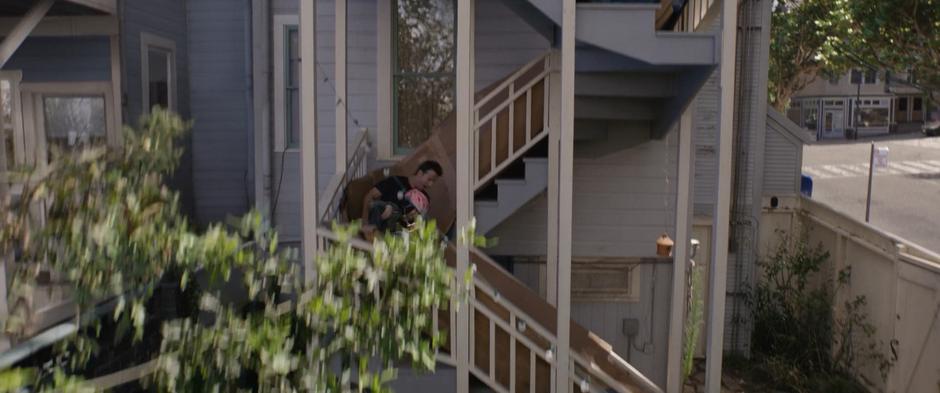 Scott and Cassie slide down a makeshift slide on the back of his house.