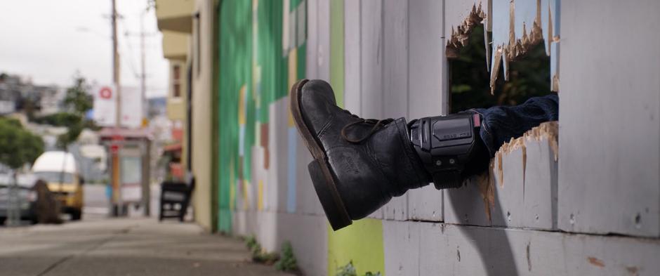 Scott's foot and ankle monitor sticks out through a hole in the fence.