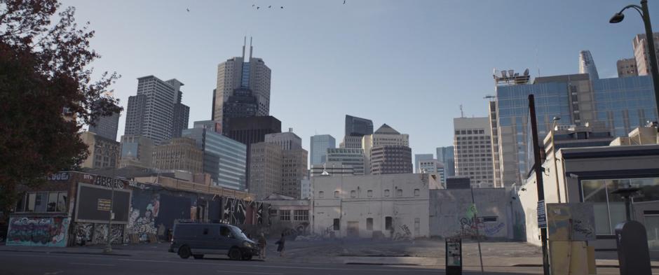 Scott jumps back as the building shrinks down in the middle of an empty lot.