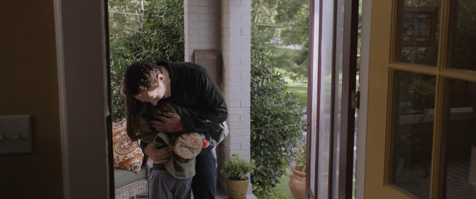 Scott hugs Cassie on the porch of the house.