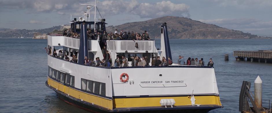 Sonny Burch watches from the back of the ferry as it pulls away from the pier.