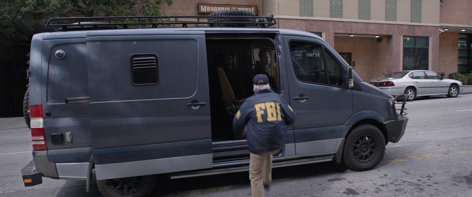 Hank steps up into the side of the van.