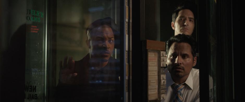 Dave, Luis, and Kurt watch Sonny Burch through the front door of the office.