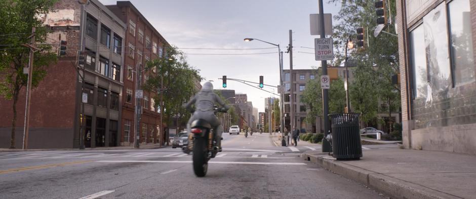 Ghost drives her newly stolen motorcycle down the street towards the other pursuers.