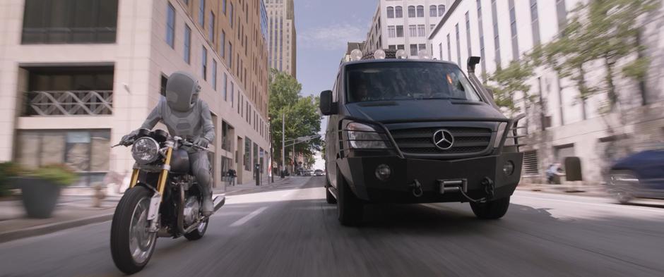 Ghost drives her motorcycle up next to Hope's van.