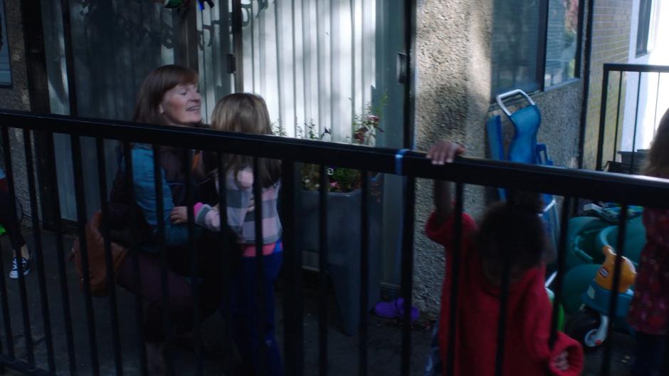 A mother plays with her kid outside her apartment.