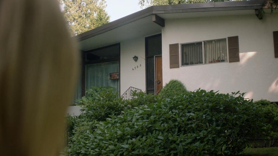 Alice looks up at the house with the room for rent sign.