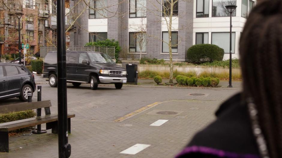 A black van pulls up in front of the cafe.