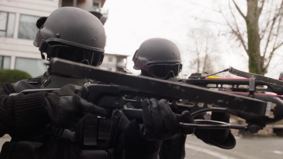 Two masked goons aim crossbows at Jada.