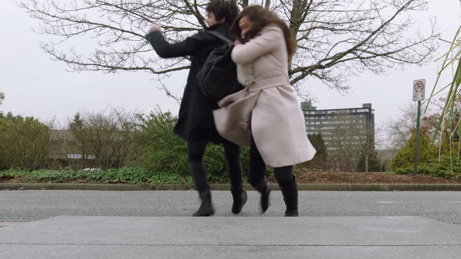 Maggie pulls Parker out of the path of an oncoming bus.