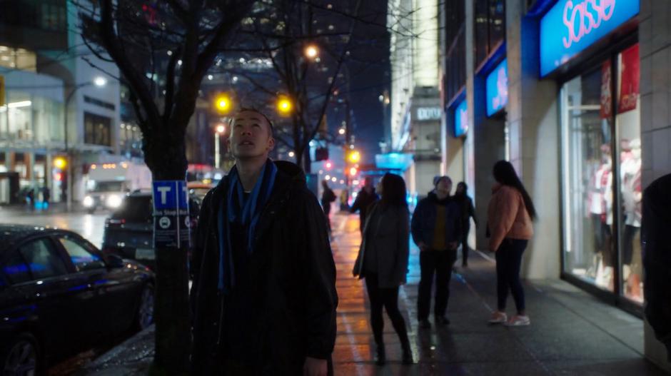 Pedestrians freeze and look up into the sky as Grodd announces himself to the city.