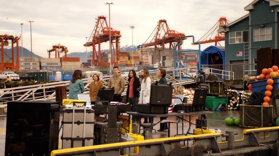 Nora, Barry, Cisco, Caitlin, and Lyla listen as Dr. Tanya Lamden explains her technology.