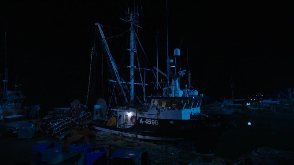 Xander walks up the gangplank onto his boat at night.