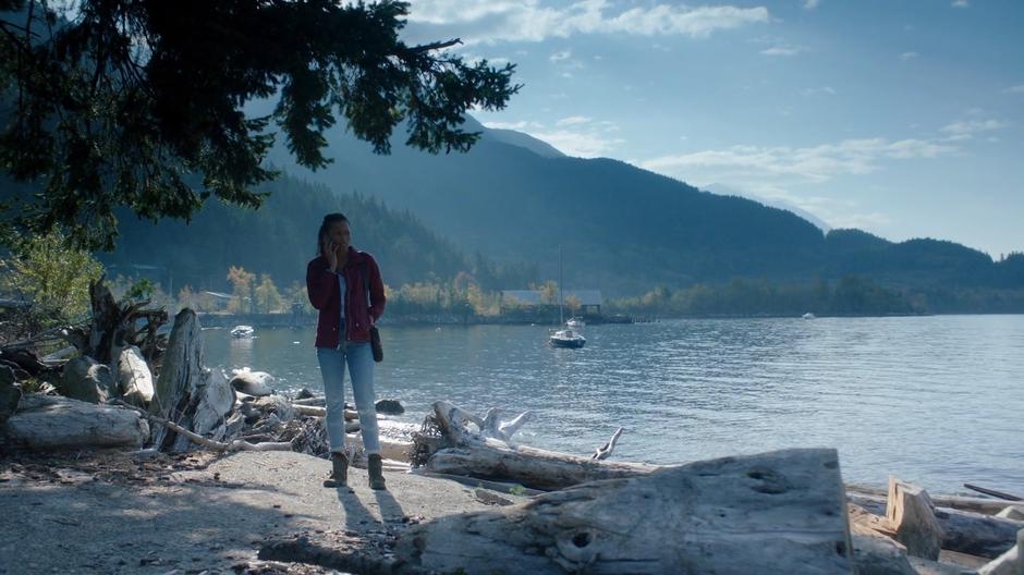 Maddie answers a phone call from her father while walking on the beach.