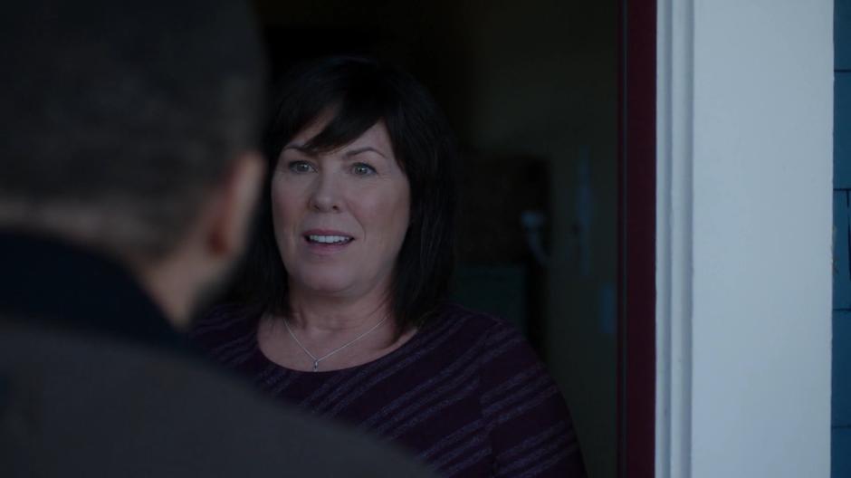 Xander's mother opens the door and smiles.