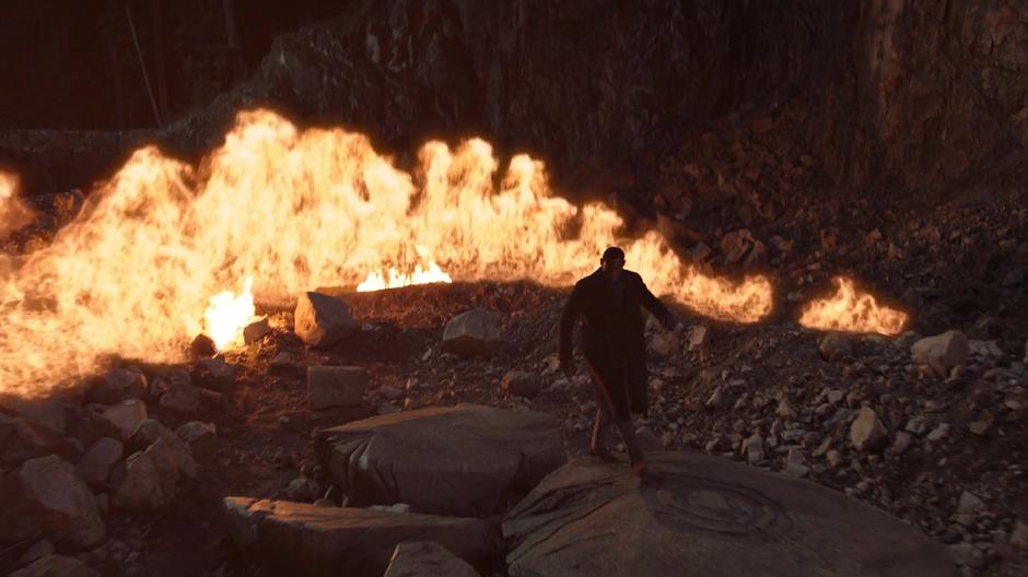 J'onn walks over to the seal as a wall of flames erupt around him.