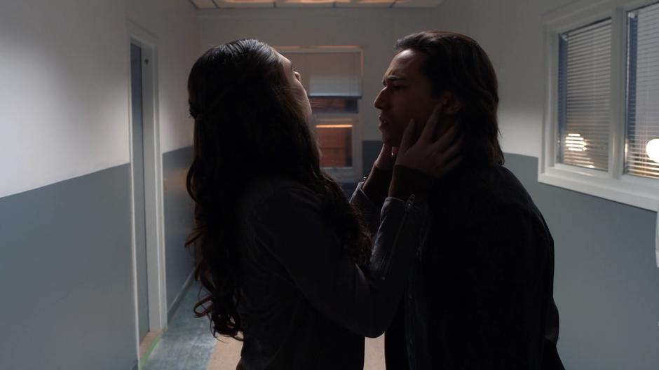 Nia pulls back and looks up at the lights after kissing Brainy.