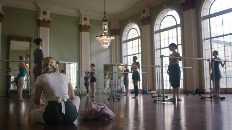 Tandy tapes up her feet while the other women stand ready at the ballet bars.