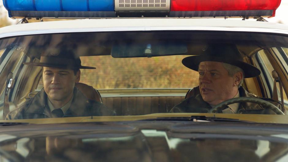 Nate and Hank talk while sitting in the car.