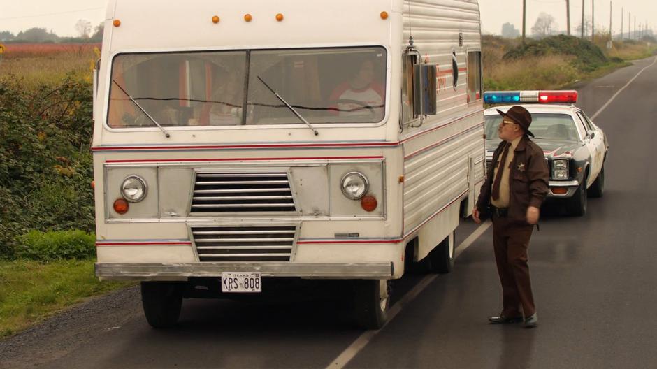 A local sheriff deputy talks to Ray who was driving the RV while Sara watches.