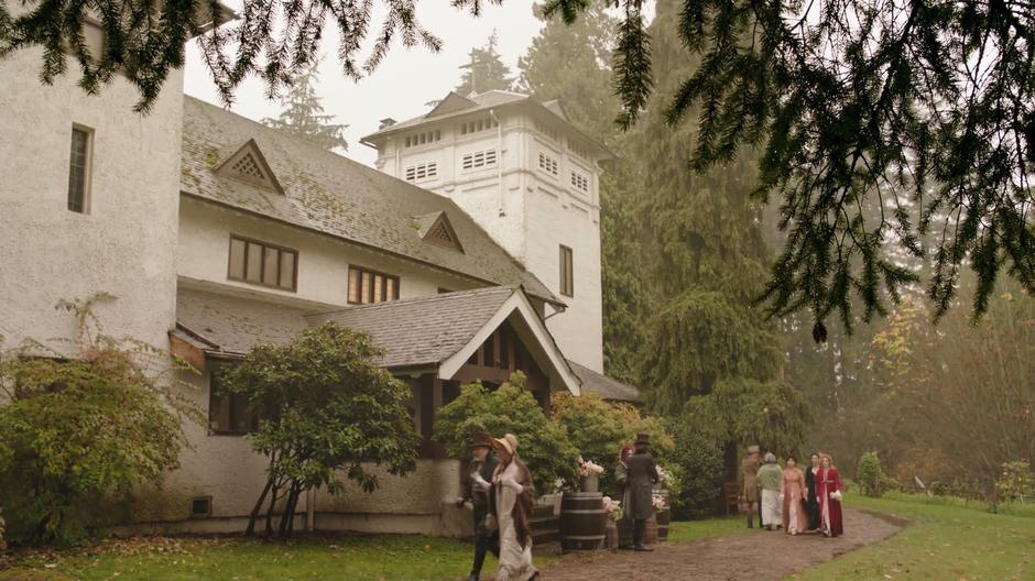 Mona, Zari, and Sara walk along the path in front of the church.