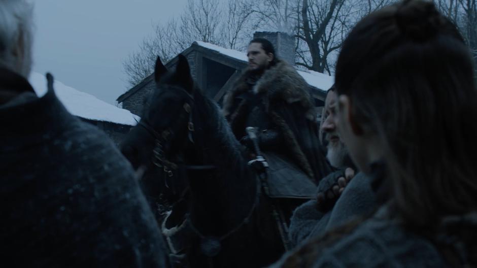 Arya watches from the crowd as Jon rides past.