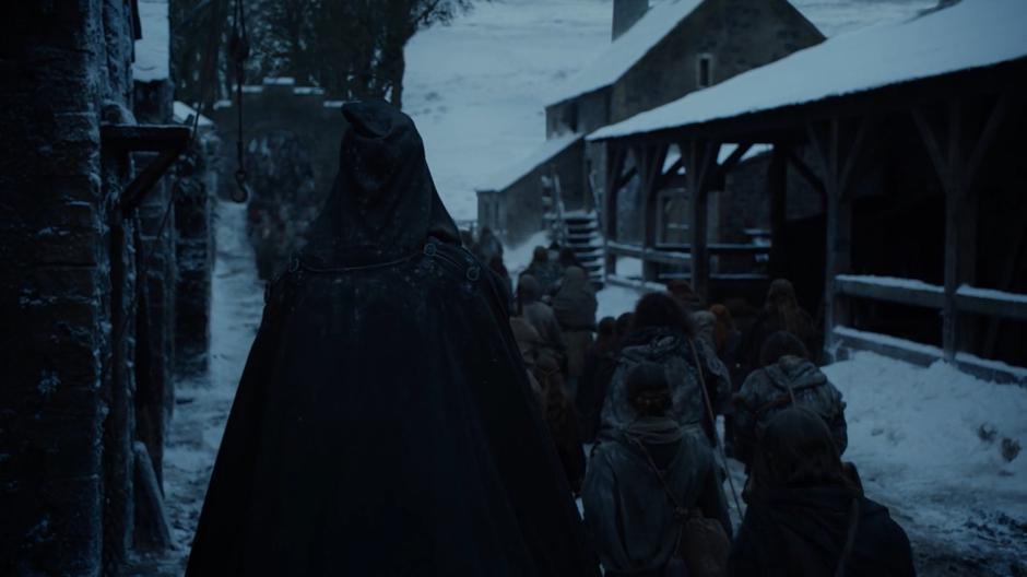 A mysterious cloaked figure rides with the line of soldiers heading towards Winterfell.